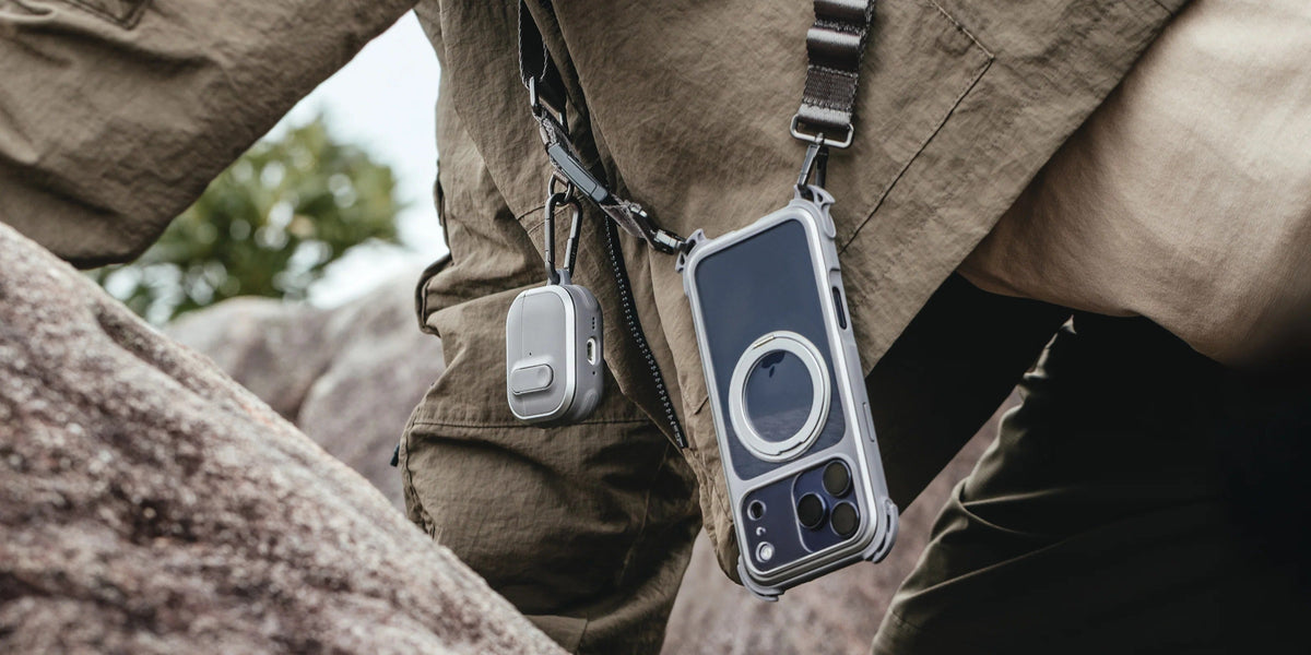 MAGEASY Odyssey outdoor AirPods Pro 3 case on a rock with wrist strap attached and AirPods displayed