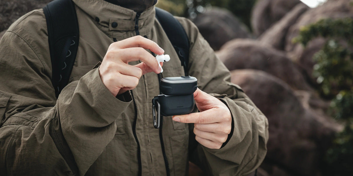 MAGEASY Odyssey rugged AirPods Pro 3 case being opened outdoors while removing an earbud