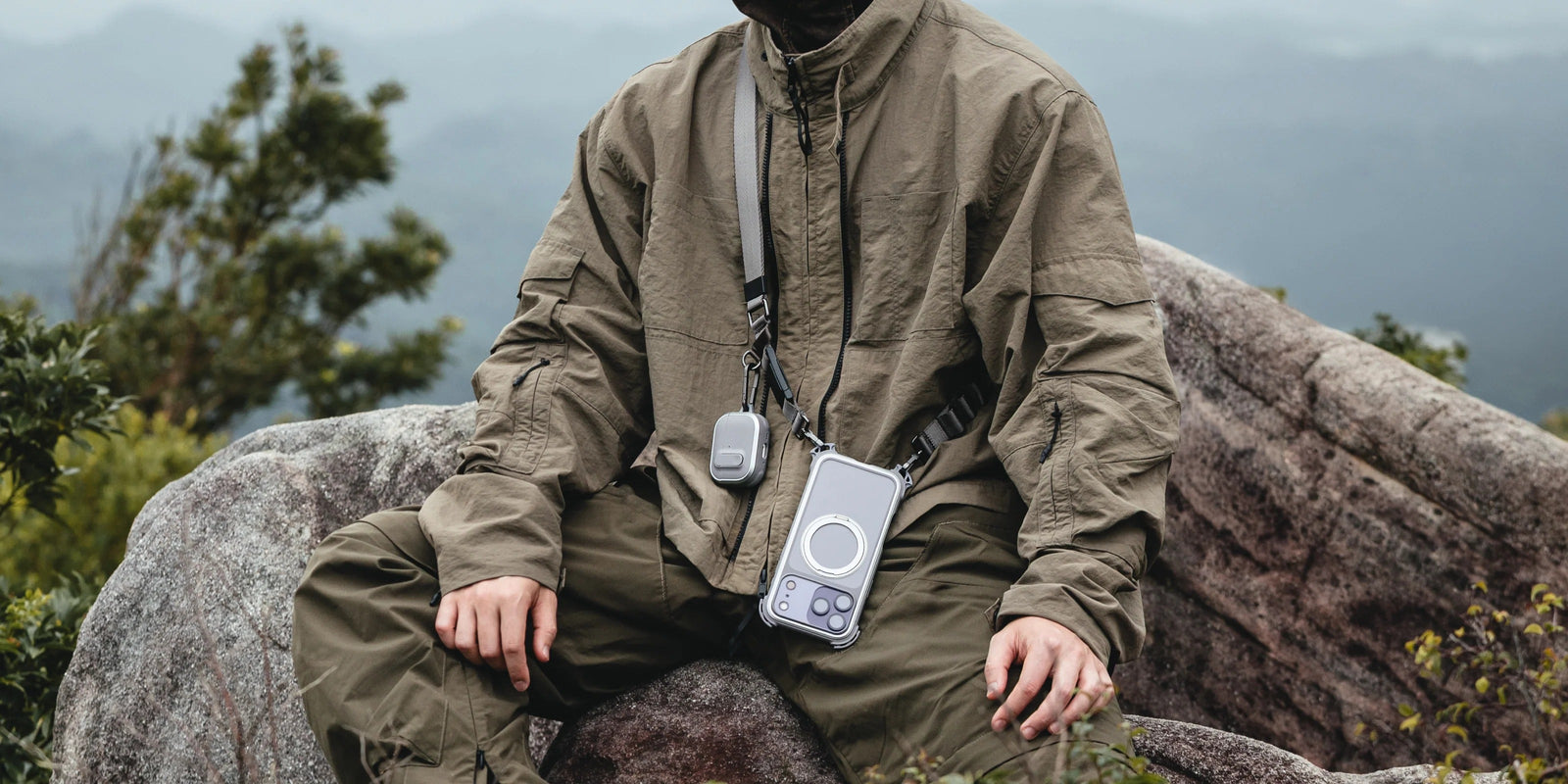 MAGEASY Odyssey outdoor AirPods Pro 3 case carried by wrist strap in an outdoor setting