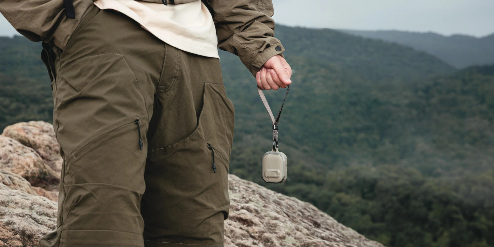 MAGEASY Odyssey rugged AirPods Pro 3 case carried by wrist strap in an outdoor setting